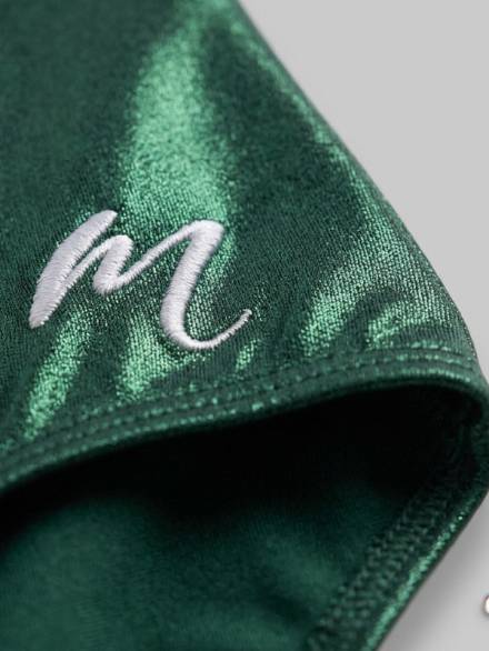 Close-up of the Modevant Aysha emerald green gymnastics leotard with embroidered M logo